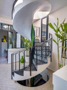 a spiral staircase in a house with plants at Riad Secret Garden Hideaway (privative) in Marrakesh