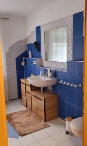 Baño azul con lavabo y aseo en Gästehaus Da Fabio, en Bad Bocklet