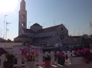 una recinzione bianca con fiori di fronte a una chiesa di B&B La Maison Del Borgo Antico a Bari