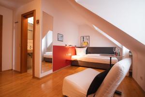 a bedroom with a bed and a staircase in a room at Hotel am Main in Veitshöchheim