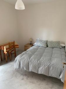 une chambre blanche avec un lit et une chaise dans l'établissement Habitacion privada en urbanización con piscina y pista de padel, à El Puerto de Santa María