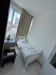 a small bed in a room with a window at Corniche AD - Stunning Room in Abu Dhabi