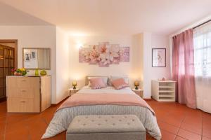 a bedroom with a large bed with pink pillows at Il colle dei Frati in Sinalunga