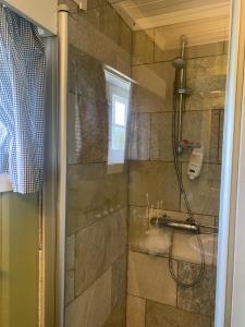 uma casa de banho com um chuveiro e uma porta de vidro em Koselig familiehytte ved Bardola em Geilo