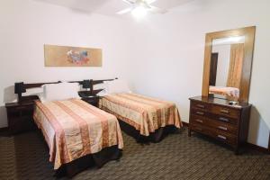 a hotel room with two beds and a mirror at Los Pinos Resort & Spa Termal All Inclusive in Termas de Río Hondo