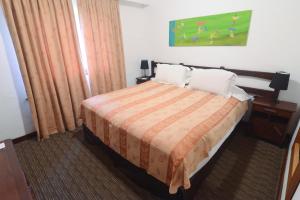 a hotel room with a bed with two pillows at Los Pinos Resort & Spa Termal All Inclusive in Termas de Río Hondo