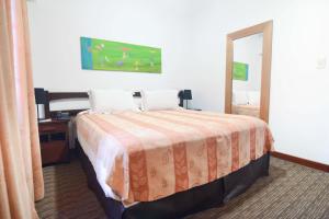 a hotel room with a bed and a mirror at Los Pinos Resort & Spa Termal All Inclusive in Termas de Río Hondo