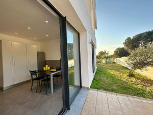 a dining room with a table and large glass windows at Gold Palm Villa in La Marsa