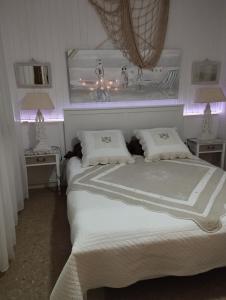 a bedroom with two beds with lights on the wall at CHAMBRES D'HÔTES CHEZ CATHERINE A REUS chambre bord de mer avec salle de bains privée in Reus