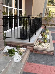 a porch with a black fence and a plant at Vera's Luxury Home in Munyonyo