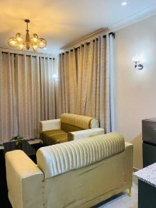 uma sala de estar com duas cadeiras e um sofá em Vera's Luxury Home em Munyonyo