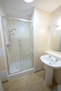 uma casa de banho com um chuveiro e um lavatório. em Seabank Hotel em Porthcawl