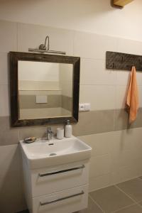 La salle de bains est pourvue d'un lavabo et d'un miroir. dans l'établissement Ubytování U Starých, à Zaječí