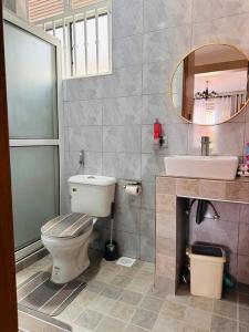 a bathroom with a toilet and a sink and a mirror at Vera's Luxury Home in Munyonyo