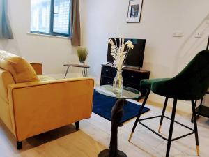 ein Wohnzimmer mit einer Couch und einem Tisch und einem Stuhl in der Unterkunft Market Haven Deluxe Studios Town centre with Netflix, Business & Leisure Travellers in Northampton