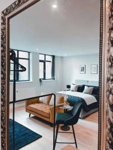 a mirror in a bedroom with a bed and a chair at Market Haven Deluxe Studios Town centre with Netflix, Business & Leisure Travellers in Northampton