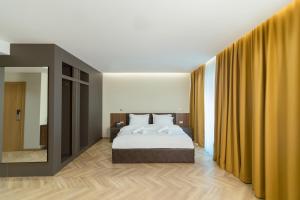 1 dormitorio con cama y espejo grande en La Terrazza Hotel & Restaurant, en Hani i Elezit