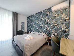 a bedroom with a bed and a floral wall at Pinea b&b in Castellaneta Marina 