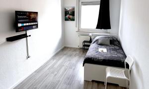 een kleine slaapkamer met een bed en een raam bij # VAZ Apartments SG01-02 ,WLAN,TV, Küche, Balkon, nahe Zentrum in Solingen