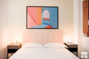 sypialnia z łóżkiem z obrazem na ścianie w obiekcie GOLDEN VIEW by Design Studio w mieście Bellano