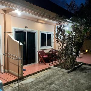 a house with a patio with a table and a chair at Kata Villa Merit Hill Bungalows in Ban Karon