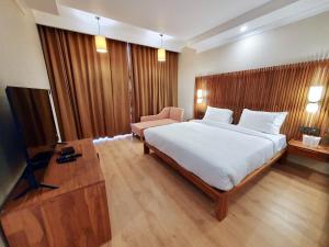 1 dormitorio con 1 cama blanca grande y 1 silla en Hotel Amanthi Ladakh en Leh
