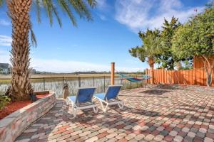 2 sillas en un patio de ladrillo con hamaca en Luxury 5br Home w Heated Pool Unbeatable Views en Tybee Island