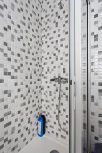 uma casa de banho com um chuveiro com azulejos brancos e cinzentos em Braganca Oporto em Porto