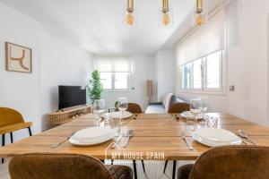 une salle à manger avec une grande table et des chaises en bois dans l'établissement MyHouseSpain - Salustio Apartments, à Gijón