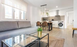 una sala de estar con un sofá y una mesa en MyHouseSpain - Salustio Apartments, en Gijón