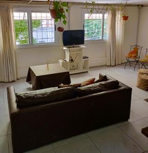 sala de estar con sofá y TV en Departamento Barrio Bombal en Godoy Cruz