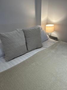 a bed with gray pillows on top of it at Stylish One Bedroom Apartment in the heart of Angel in London