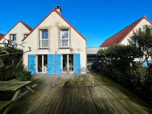 ein großes Haus mit blauen Türen auf einer Holzterrasse in der Unterkunft COC - Basse Mer in Wissant