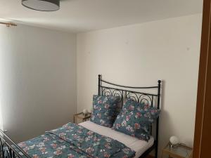 een slaapkamer met een bed met blauwe kussens bij Ferienwohnung Alex in Nusplingen