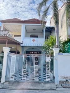 une maison avec une porte bleue et des palmiers dans l'établissement Bang Saen House: Friends/Family., à Ban Thai Don (1)