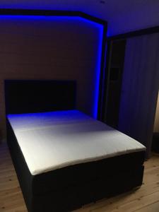 a bed in a room with a blue light at Riviera Cottage in Comblain-au-Pont