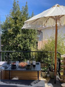 a table under an umbrella on a patio at Casa Familia in La Teste-de-Buch
