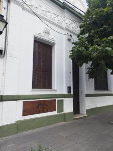 un edificio blanco con un cartel en el costado en Valhalla Hostel & Suites en Salta