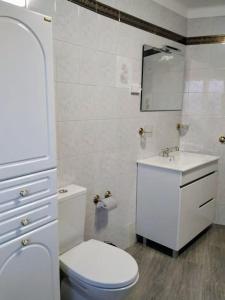 Baño blanco con aseo y lavamanos en Casa da Calçada - Casa Inteira, en Seia