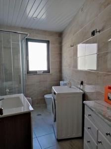 a bathroom with a tub and a sink and a toilet at Casa da Calçada - Casa Inteira in Seia