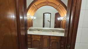 a bathroom with two sinks and a large mirror at Valhalla Hostel & Suites in Salta