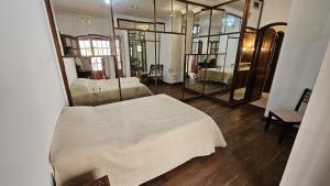una camera con letto bianco e specchio di Valhalla Hostel & Suites a Salta