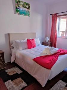a bedroom with a bed with a red blanket on it at Casa da Calçada - Casa Inteira in Seia