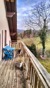 una terraza de madera con mesa y mesa de picnic en Les Hauts de Brochot, en Saint-Maurice-sur-Moselle