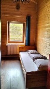 2 łóżka w drewnianym pokoju z oknem w obiekcie Les Hauts de Brochot w mieście Saint-Maurice-sur-Moselle