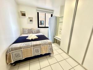 um pequeno quarto com uma cama e um frigorífico em Apartamento Beira Mar de Pajuçara / Maceió em Maceió