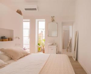 1 dormitorio blanco con 1 cama grande y espejo en Dream flat. New Brooklyn Madrid en Madrid