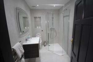 La salle de bains blanche est pourvue d'une douche et d'un lavabo. dans l'établissement Harrow Field Place, à Harrow on the Hill