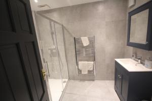 La salle de bains est pourvue d'une douche et d'un lavabo. dans l'établissement Harrow Field Place, à Harrow on the Hill