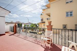 un balcón con 2 sillas blancas y una valla en Estudio en la Carihuela, en Torremolinos